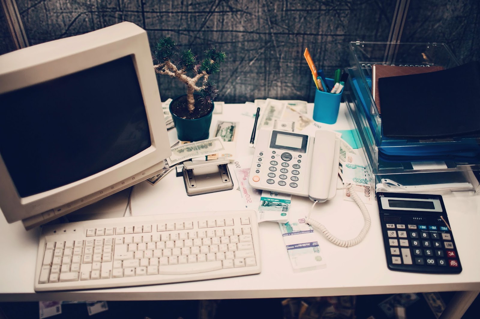 Old computer and calculator in an office that needs business technology management.