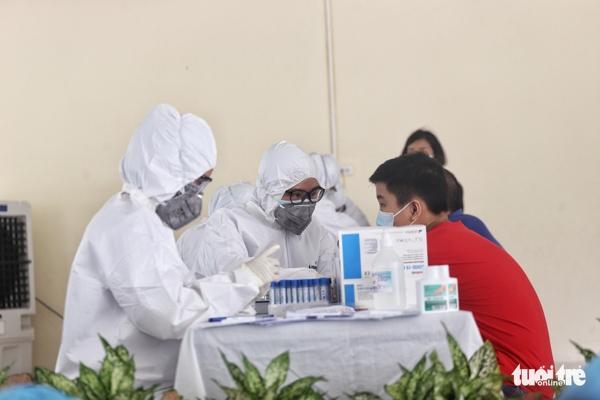 Các nhân viên y tế của TP Hà Nội thực hiện xét nghiệm nhanh cho người dân. Ảnh: TTO