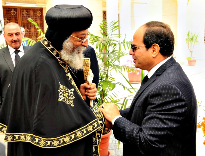 In this photo provided by Egypt's state news agency, MENA, Egyptian President Abdel-Fattah el-Sissi, right, offers condolences to Coptic Pope Tawadros II for the victims of twin bombings on Palm Sunday in the cities of Tanta and Alexandria, at St. Mark's Cathedral, in Cairo, Egypt, Thursday, April 13. 