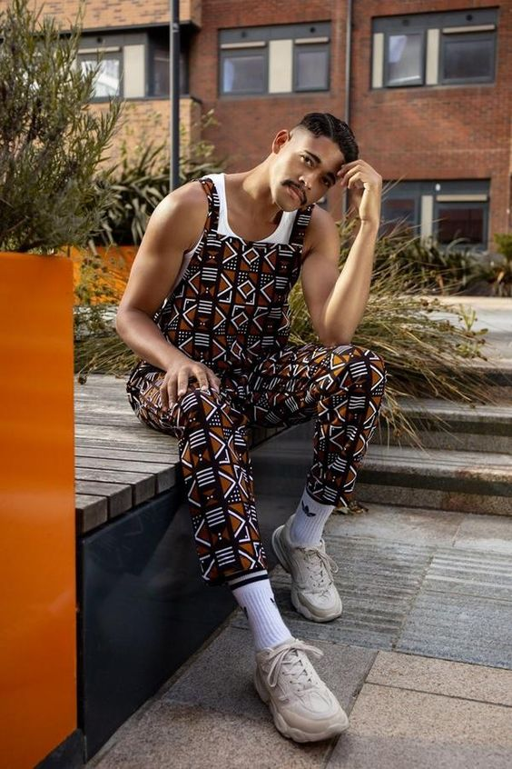 man wearing ankara dungaree and seated for a photoshoot