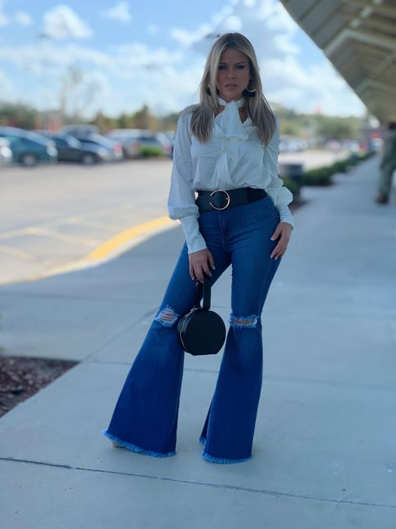 a lady pairing her high-waist flare jeans with a white shirt

