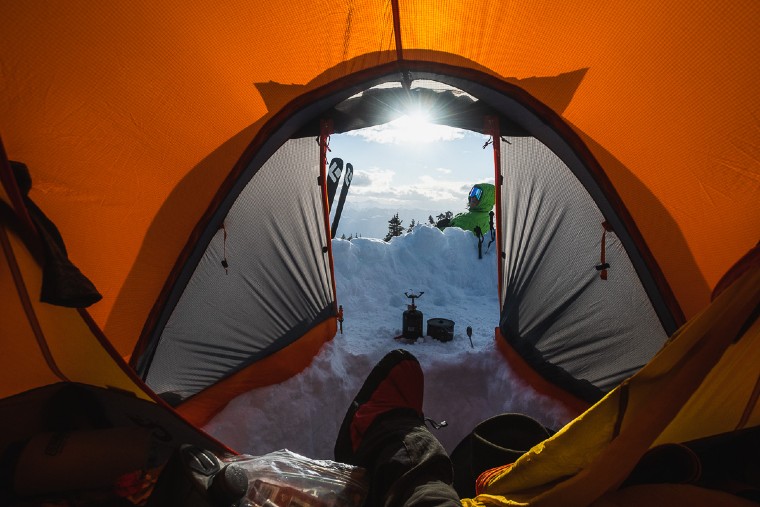 Camper looking out of the NEMO Chigori Mountaineering Tent in the morning during a winter camping trip.