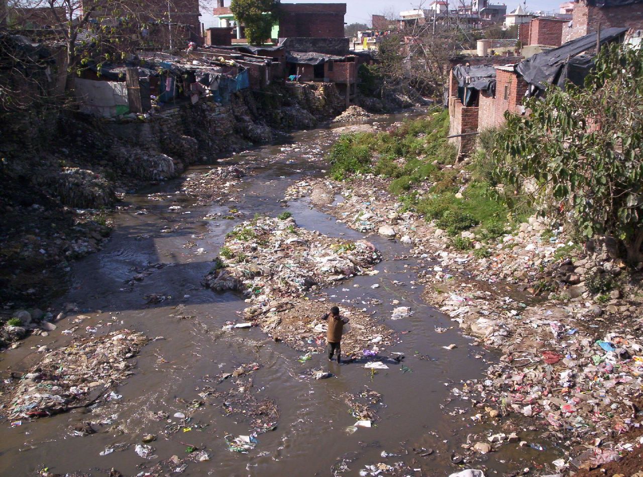 https://upload.wikimedia.org/wikipedia/commons/e/e8/Slum_and_dirty_river.jpg