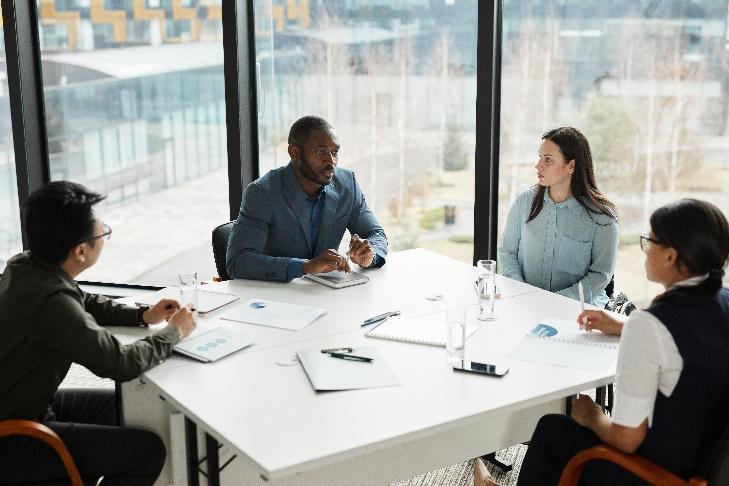 A group of people sitting around a table

Description automatically generated with medium confidence