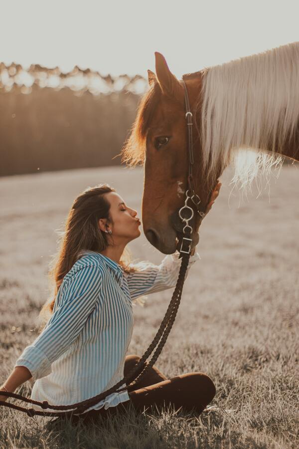 Mulher beijando carinhosamente um cavalo