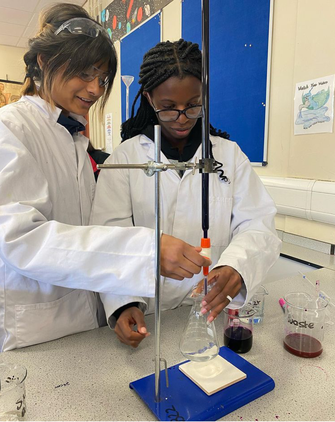 Piper's Hill College students in the science lab carrying out a lab test with white coats and goggles on