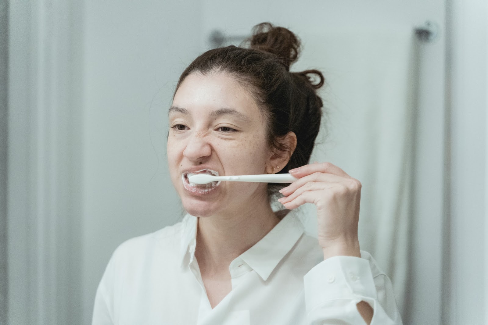 adult woman brushing teeth in mirror, toothbrush, hygiene, oral health