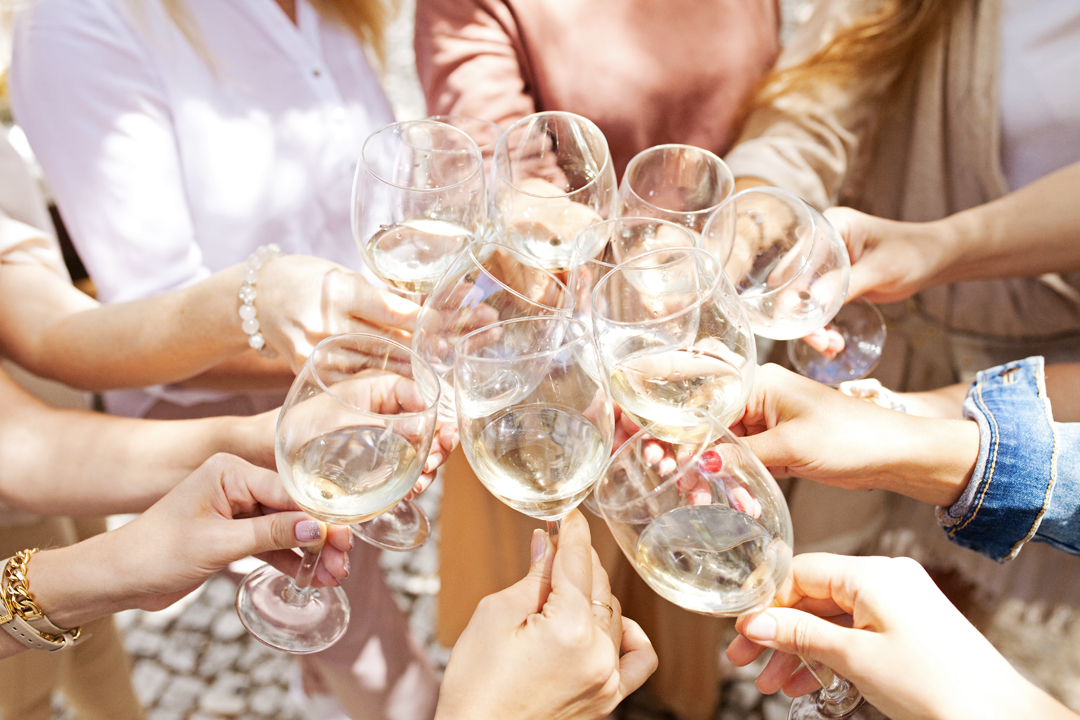 A picture of multiple wine glasses cheering