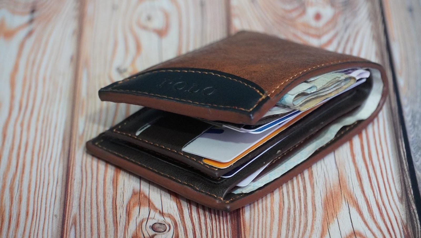 A wallet full of credit cards and money. 