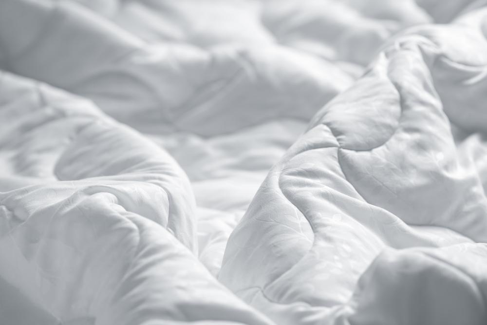 A picture containing bed, indoor, bedclothes, clothing
Description automatically generated