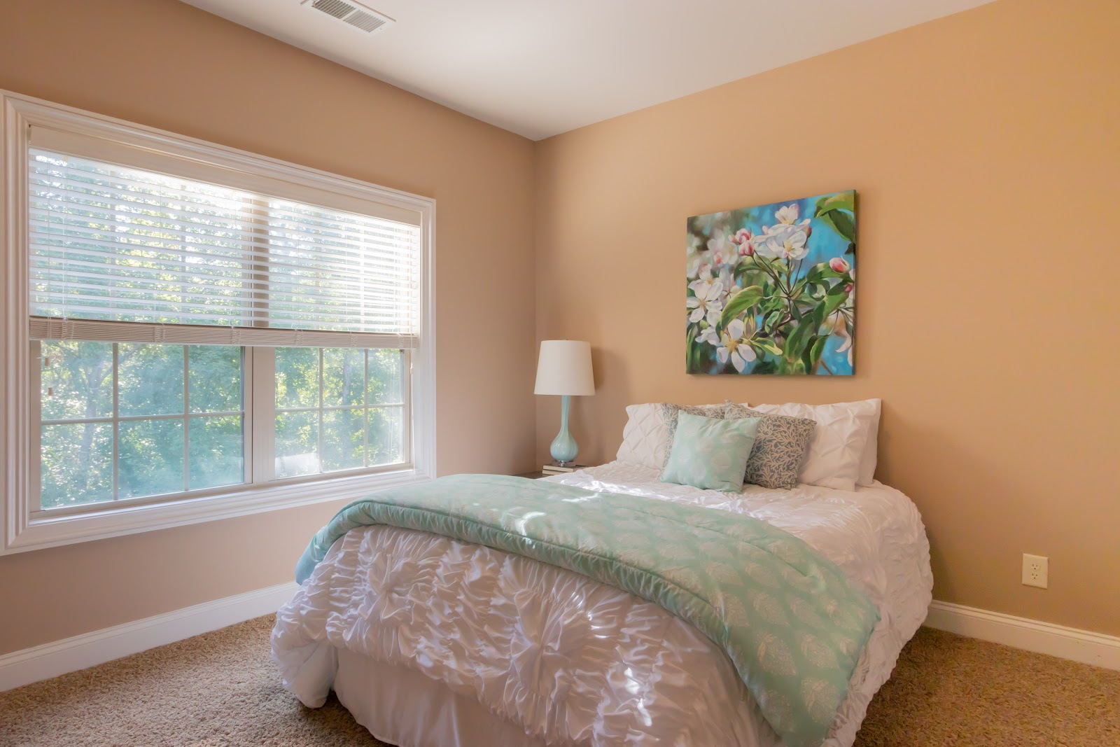 When staging a bedroom be sure to use light bedding in a neutral color and plenty of space to walk around the room.