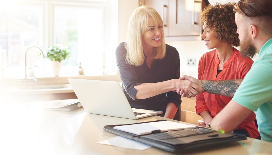 Man and woman meeting with a real estate agent in their home