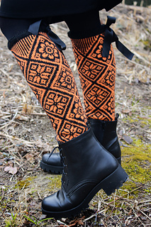 person wearing tall orange and black colorwork socks with boots