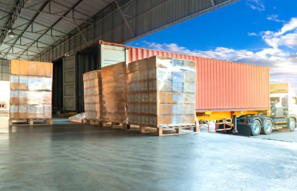 Warehouse and Logistics transportation, stack of cardboard boxes or cargo shipment on pallet for loading into a truck Freight transportation by trucks, trucks trailer docking loading cargo at warehouse shipping container storage stock pictures, royalty-free photos & images