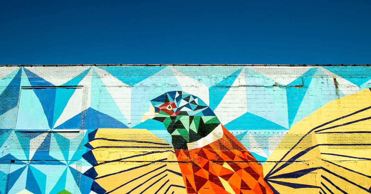 A colorful mural of a bird in a cubist style in shades of orange, green, and turquoise blue.