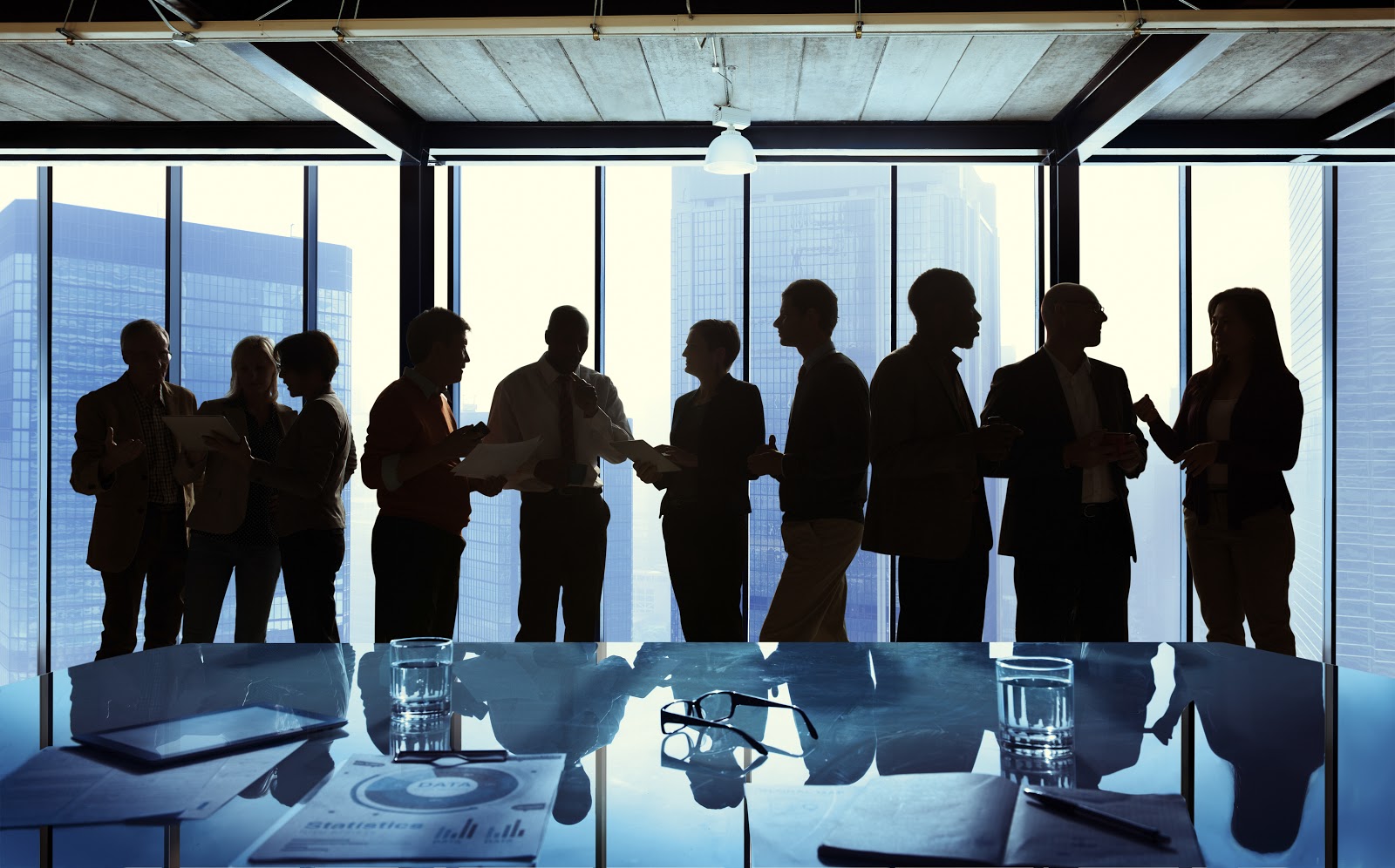 Funcionários de empresa conversam em sala de reunião.