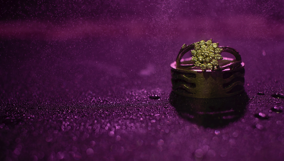 A gold ring on a purple surface