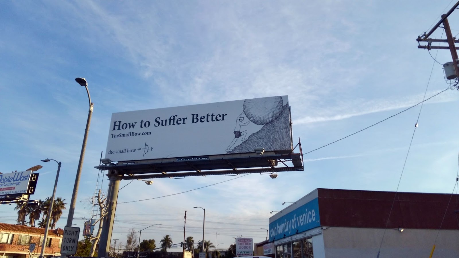 The billboard for The Small Bow, featuring a person pushing a rock up a hill, and the words, "How to suffer better."