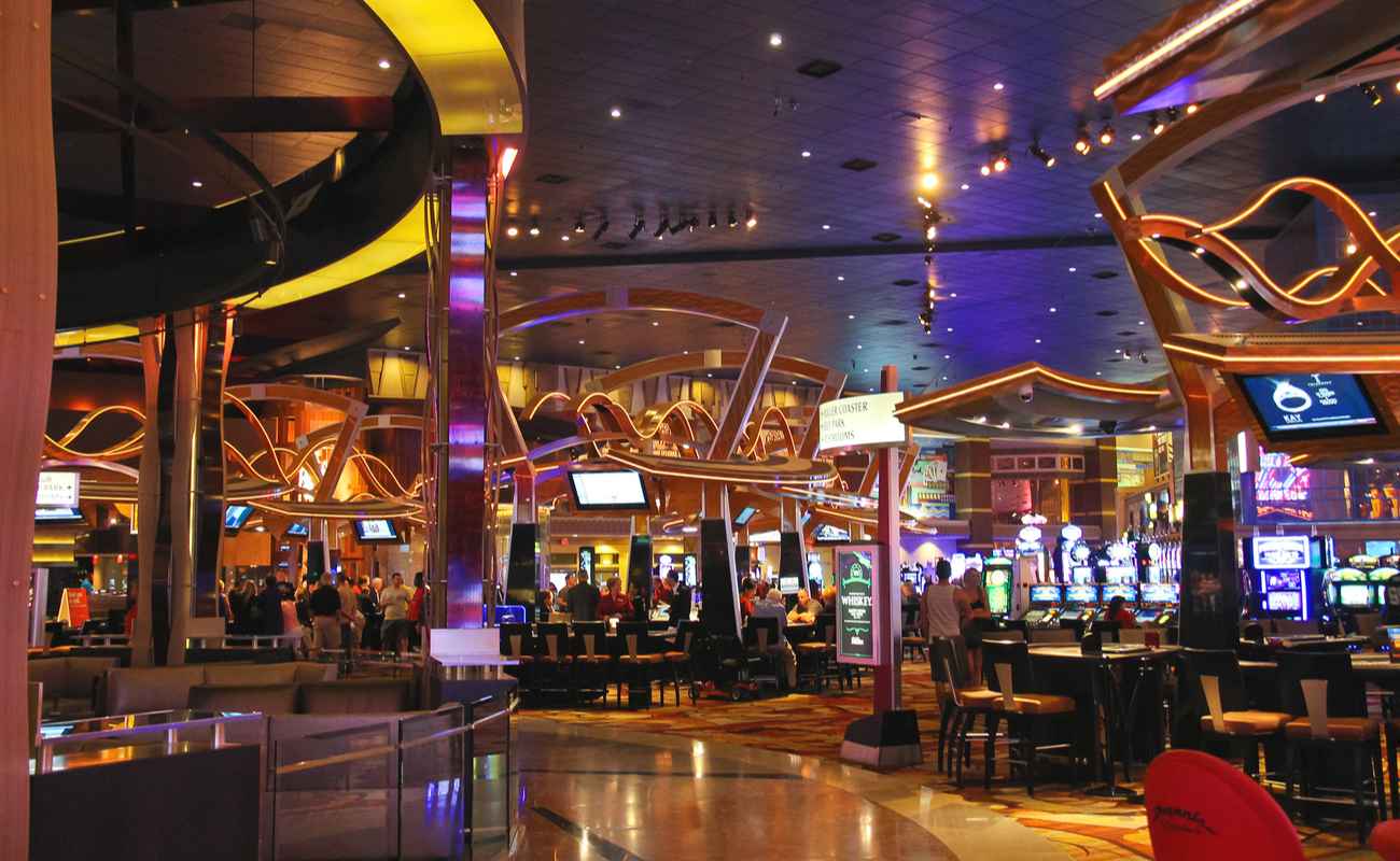 Inside of a casino lit up with lights from casino games and TVs