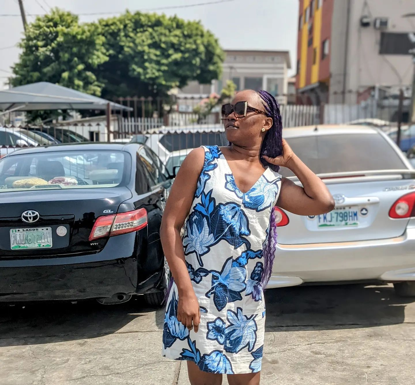 Victoria Willie in a blue and white short floral dress  with sunglasses