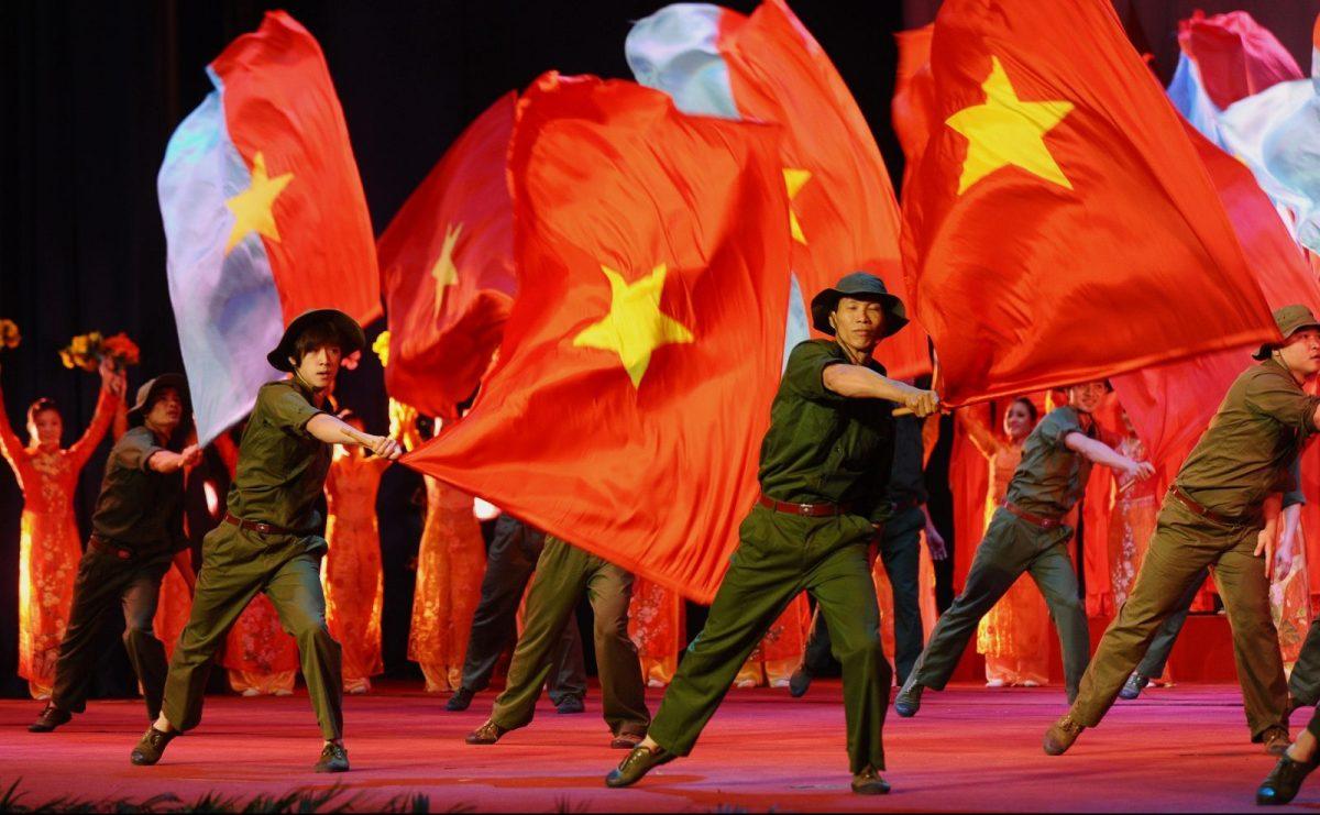 Performers dance with large national flags marking an anniversary of Vietnam's communist regime in Hanoi, February 3, 2017.  Photo: AFP/Hoang Dinh Nam