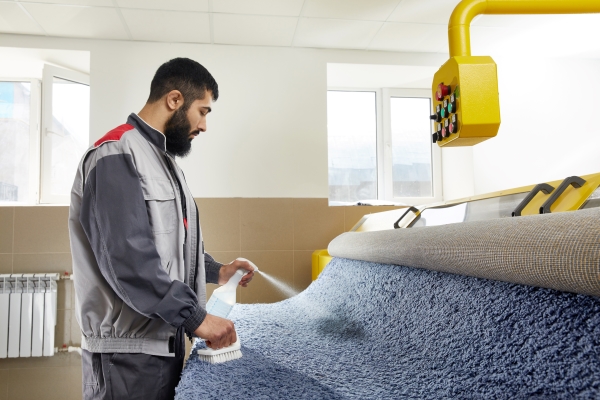 man-using-spray-remove-stain-from-carpet-carpet-cleaning-service