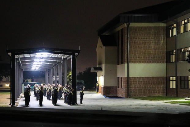 Basic Combat Training recruits at Fort Jackson, South Carolina stand in formation before dawn and await the day's tasks.