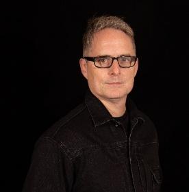 A person wearing glasses and a black shirt

Description automatically generated