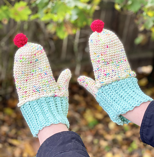 a hands wearing cozy cupcake mittens
