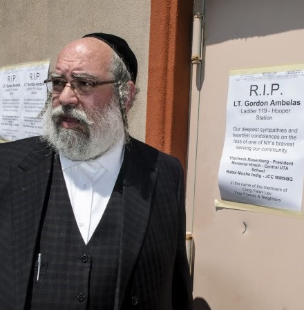 Rabbi Lieb Glantz from Central UTA passing posters with sympathy for the Fire Fighter Satmar synagogue is across the fire house where Ambelas was stationed.