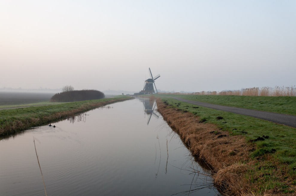 windmills near the river in cloudy weather