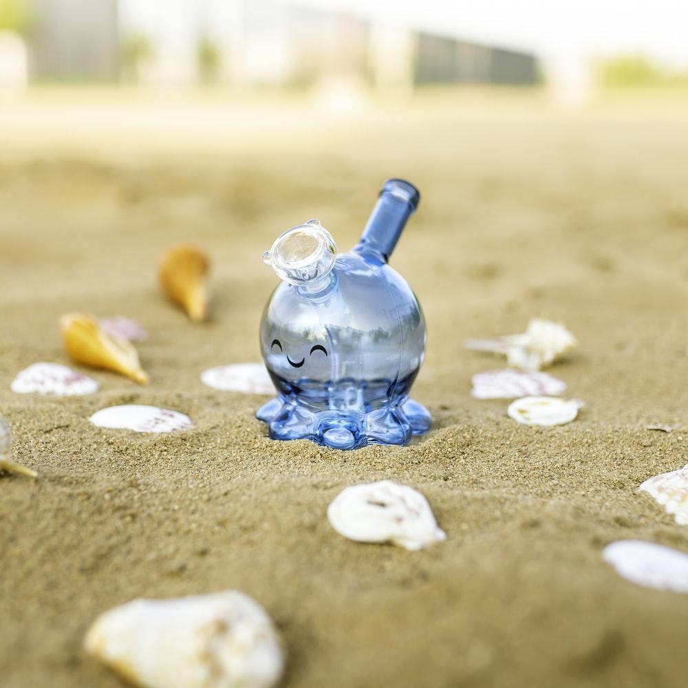 blue glass bottle on brown sand