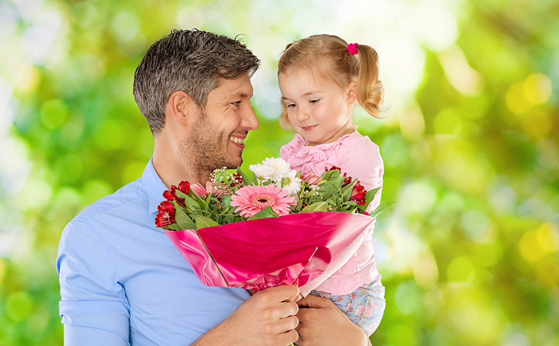 pai recebendo buquê de flores de Dia dos Pais da filha pequena