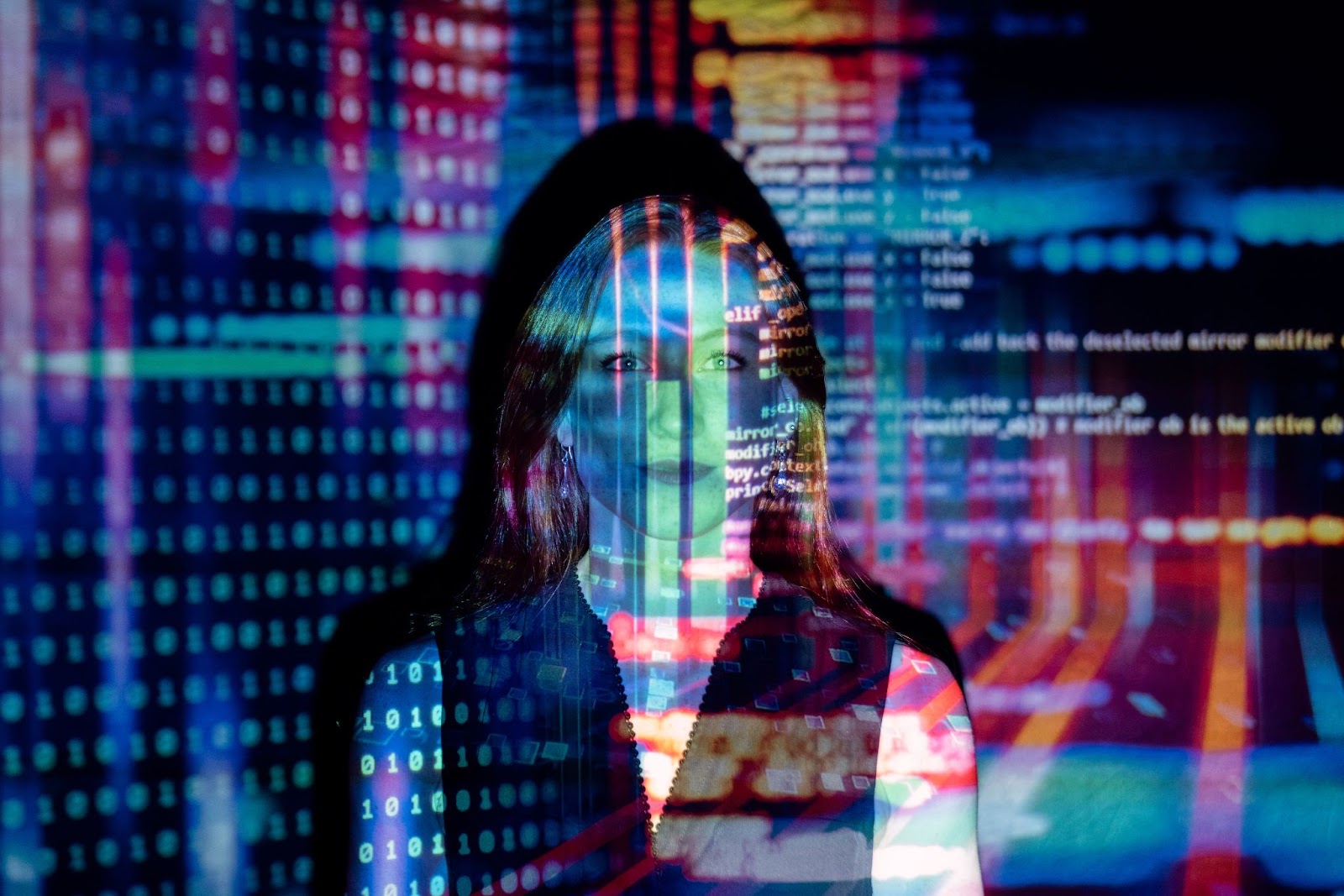 A lady standing in front of multiple codes projected on her face