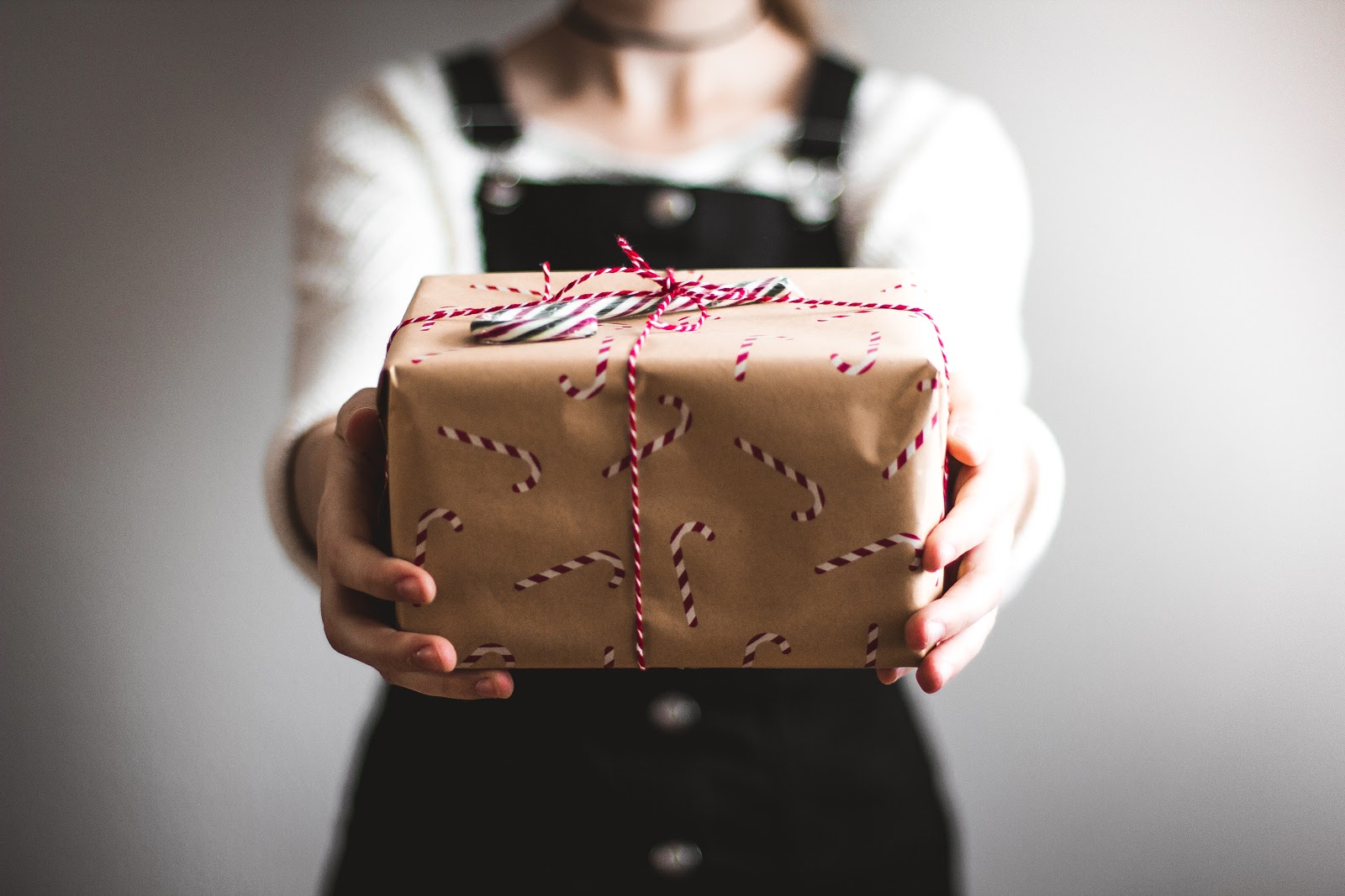 A person holding a wrapped holiday gift