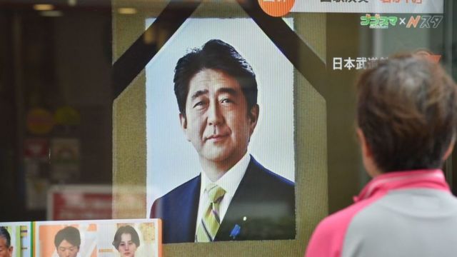 Mujer ve en una pantalla las informaciones sobre el funeral del ex primer ministro Shinzo Abe, asesinado en 2022.