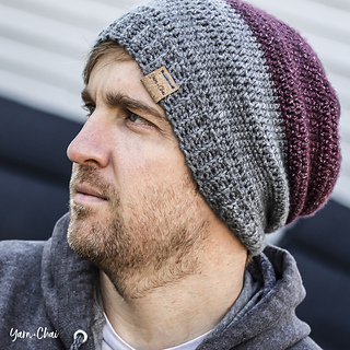 man wearing a gray and maroon crocheted hat