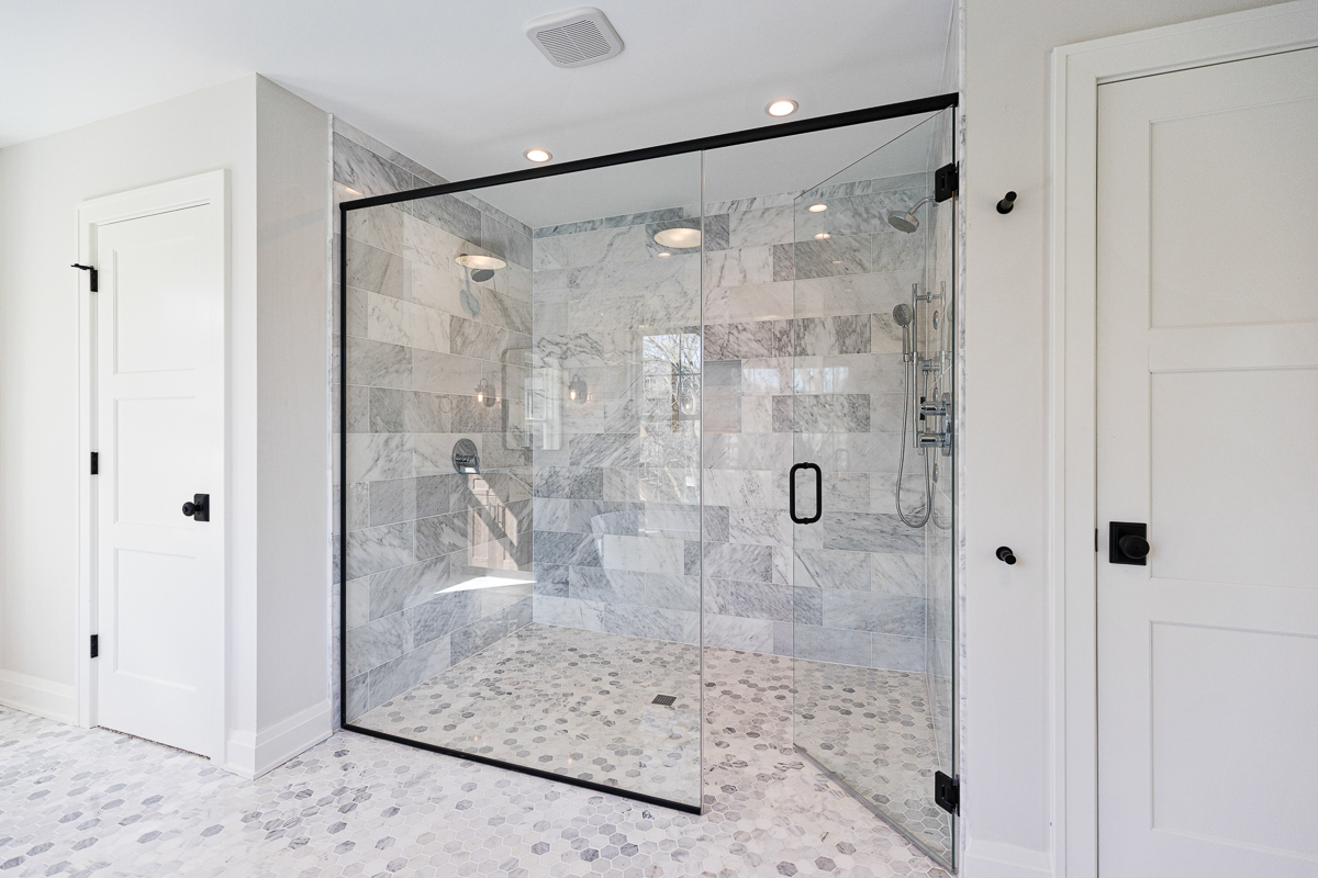 Large, frameless barrier-free shower with marble tile