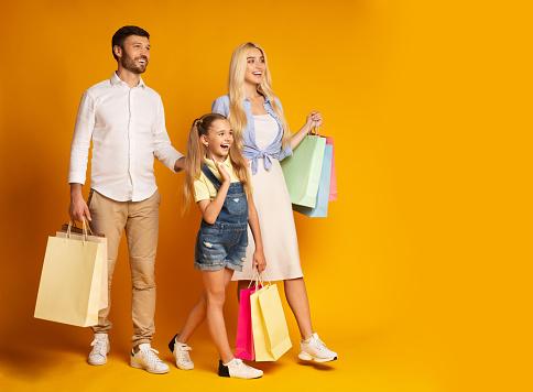 Family Carrying Colorful Shopping Bags Walking Over Yellow Background Stock  Photo - Download Image Now - iStock