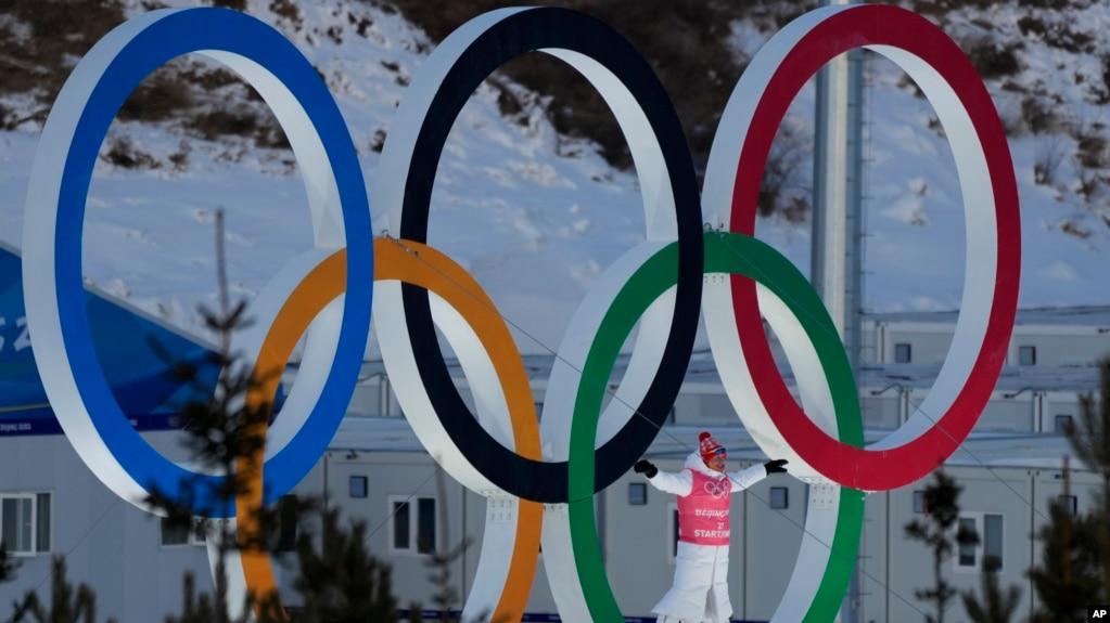 一名运动员站在北京冬奥赛场的奥运会五环里。（2022年2月3日）