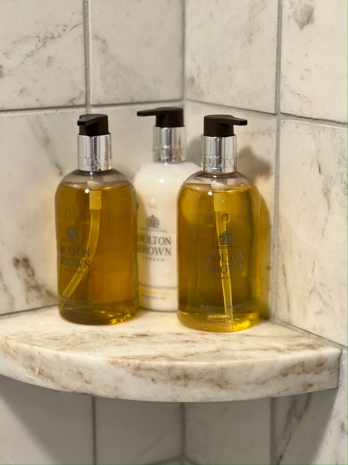 a group of soap bottles on a marble shelf