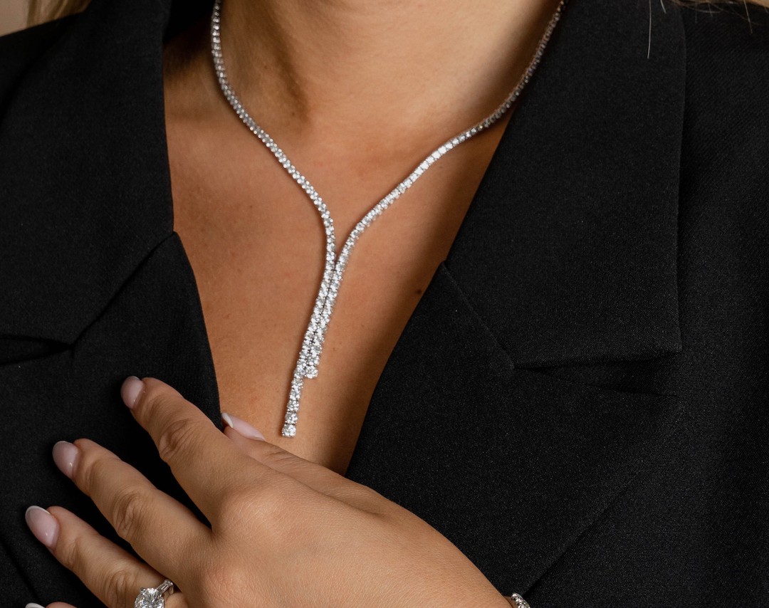 woman in a black shirt with a diamond necklace and ring