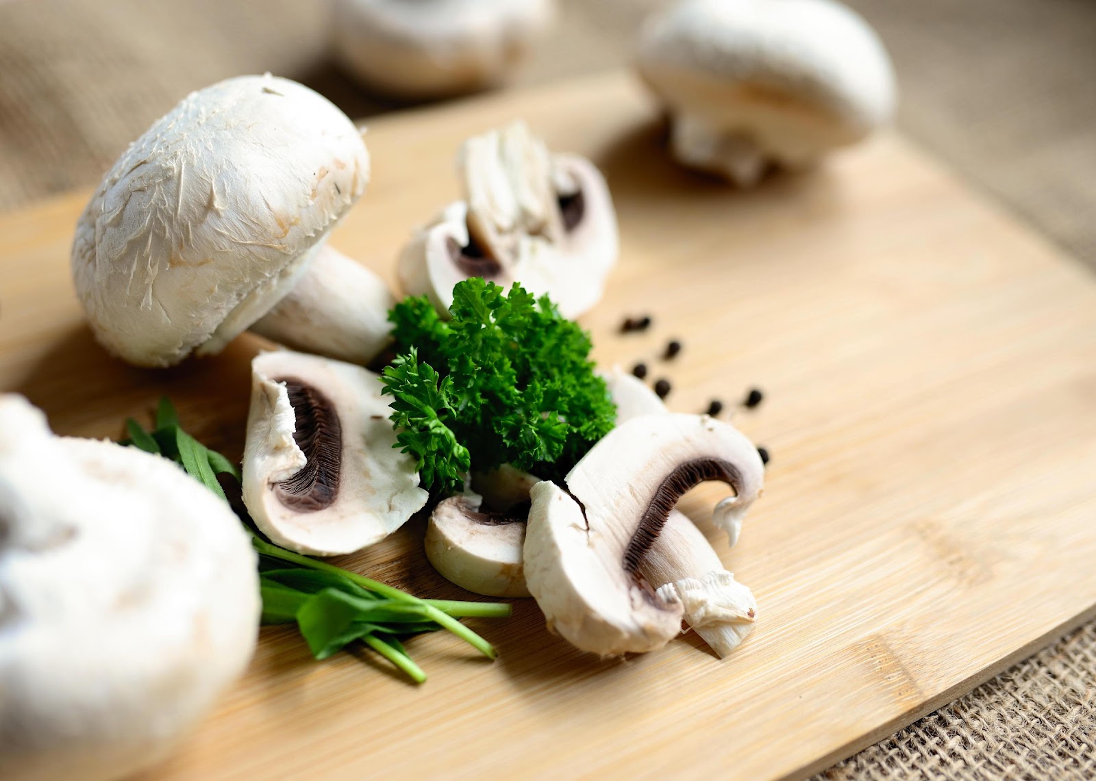 mushrooms parsley and whole spice on a wooden counter