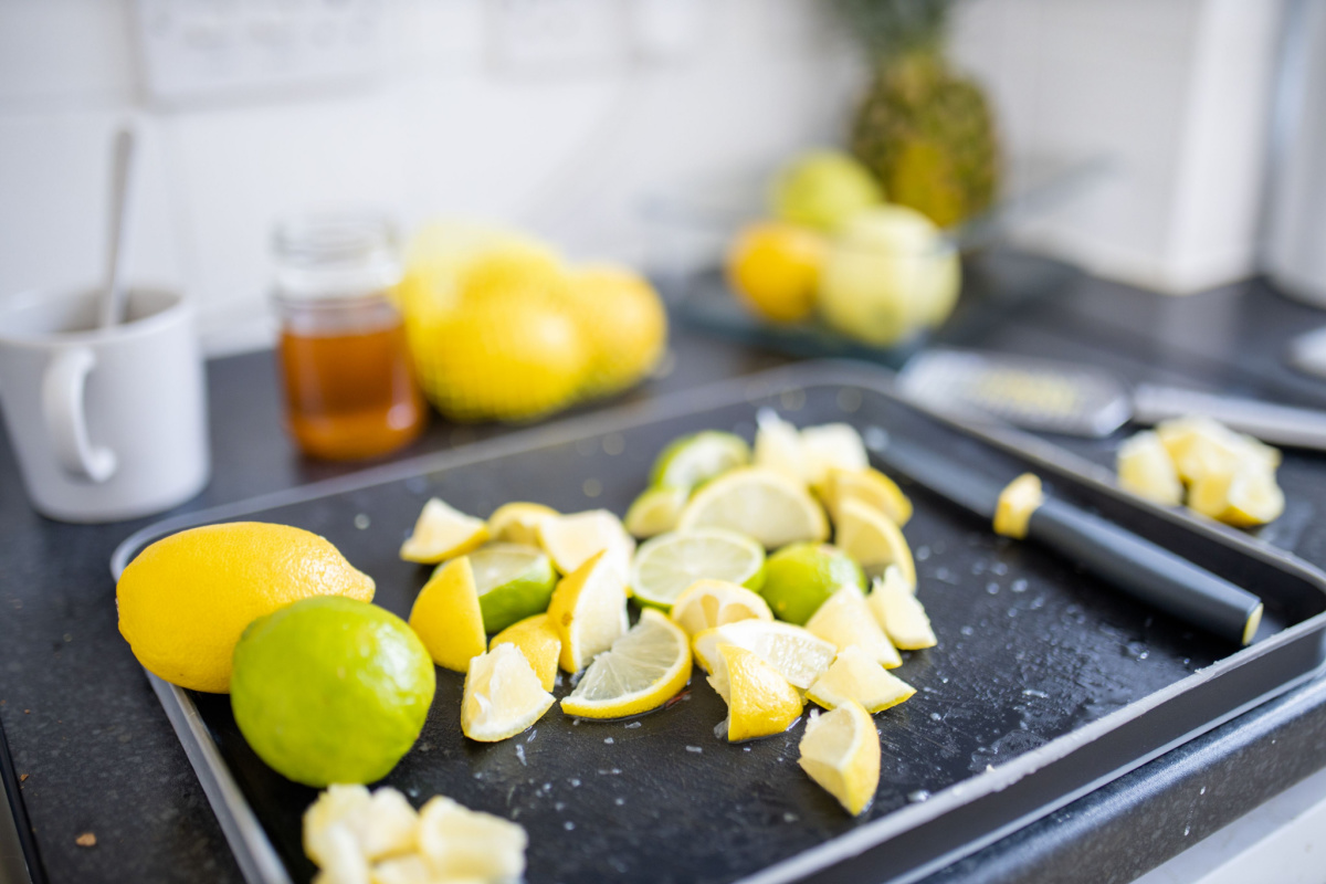 Clopped lemons sitting on a pan. There is a knife on the pan.