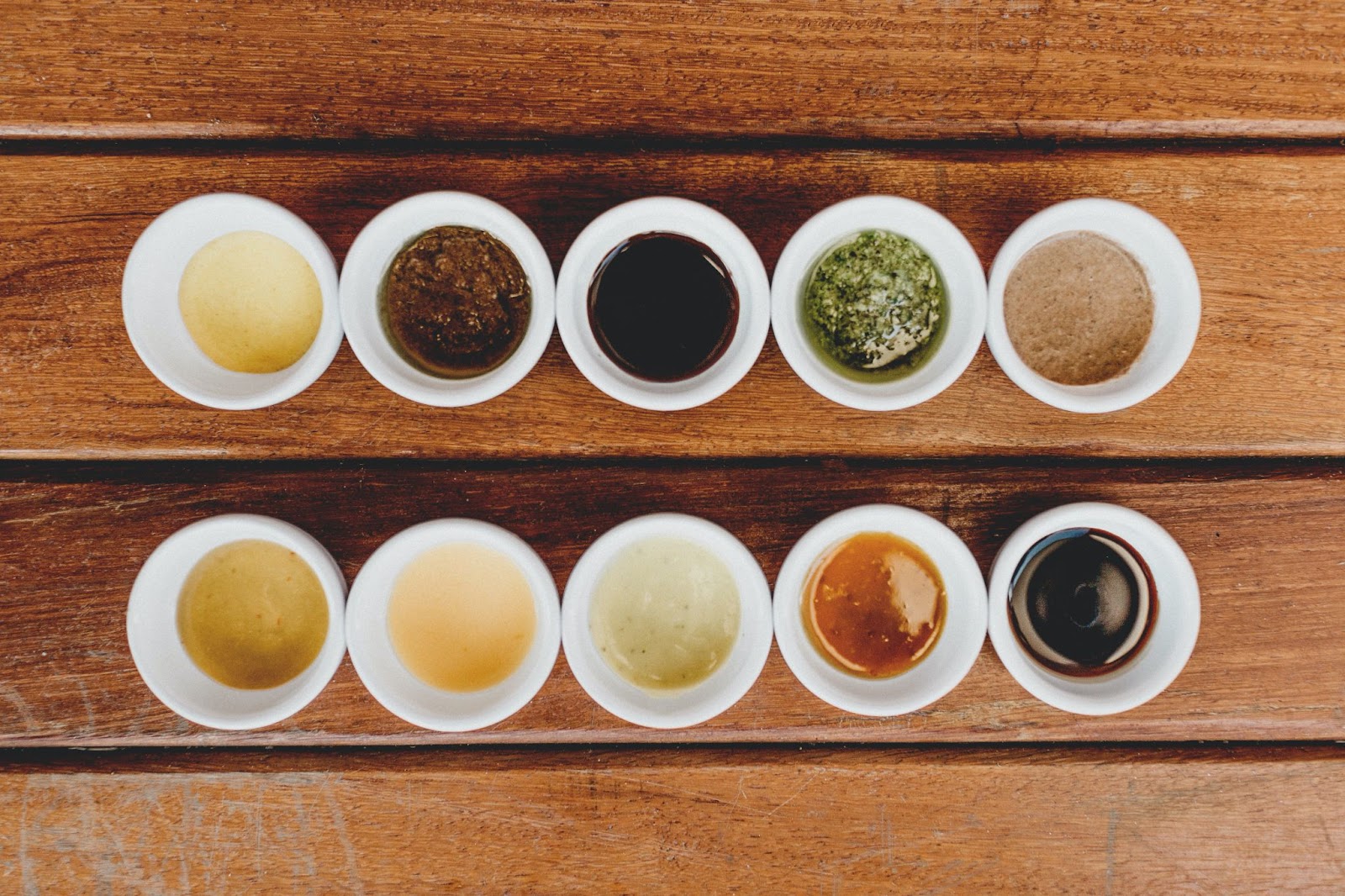 Ten varieties of tea arranged in two rows, in white bowls.