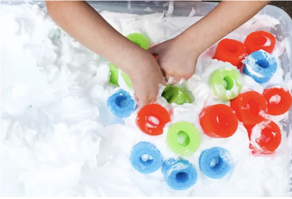 child playing in a shaving cream sensory bin