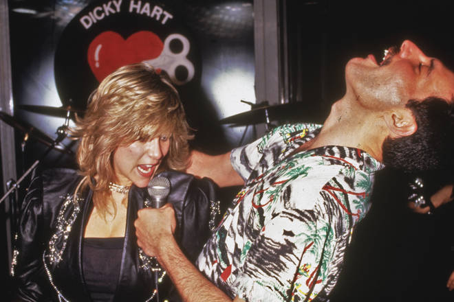 Freddie Mercury performs a duet with Samantha Fox during a party at Kensington Roof Gardens in London, 12th July 1986.