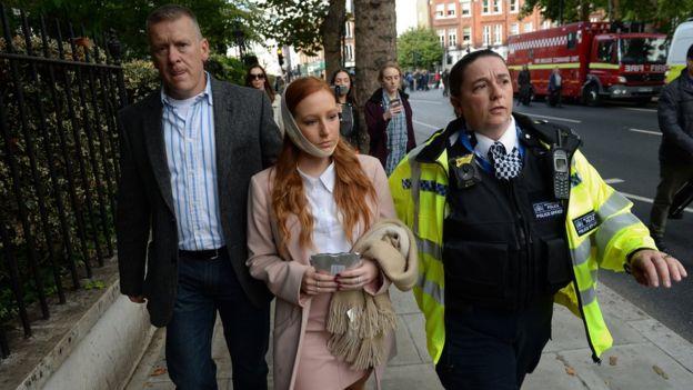  female casualty is led from the scene by a police officer