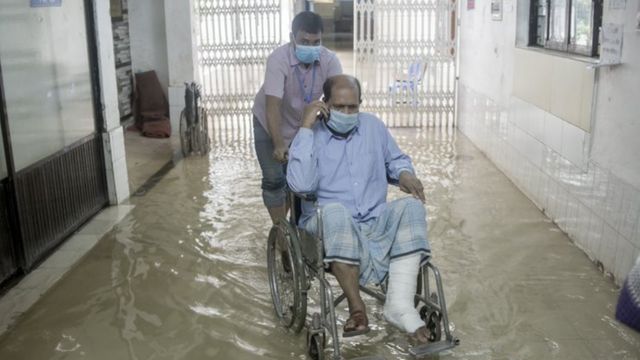 Hombre en silla de ruedas en un pasillo inundado