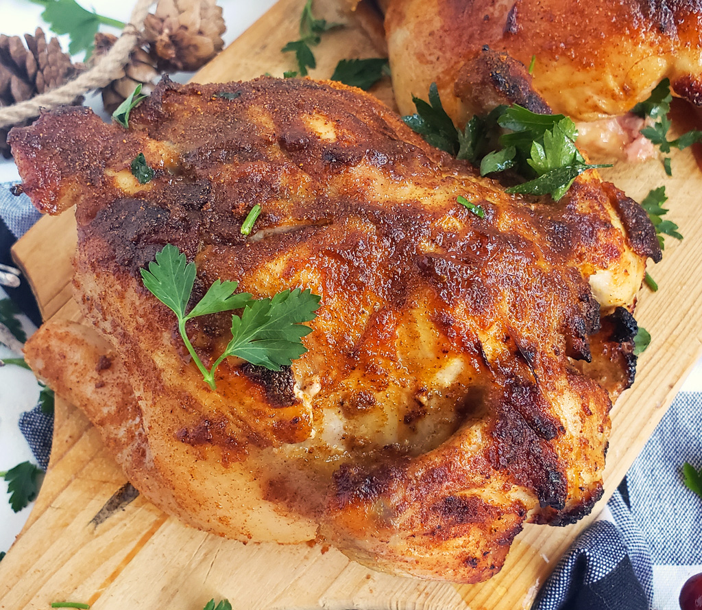 Honey Mustard Cornish Hens with a crispy crust on a wooden board